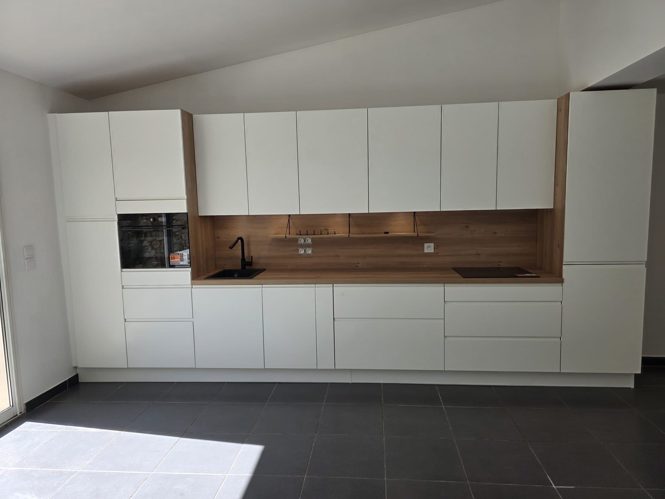 Cuisine blanche linéaire avec crédence bois