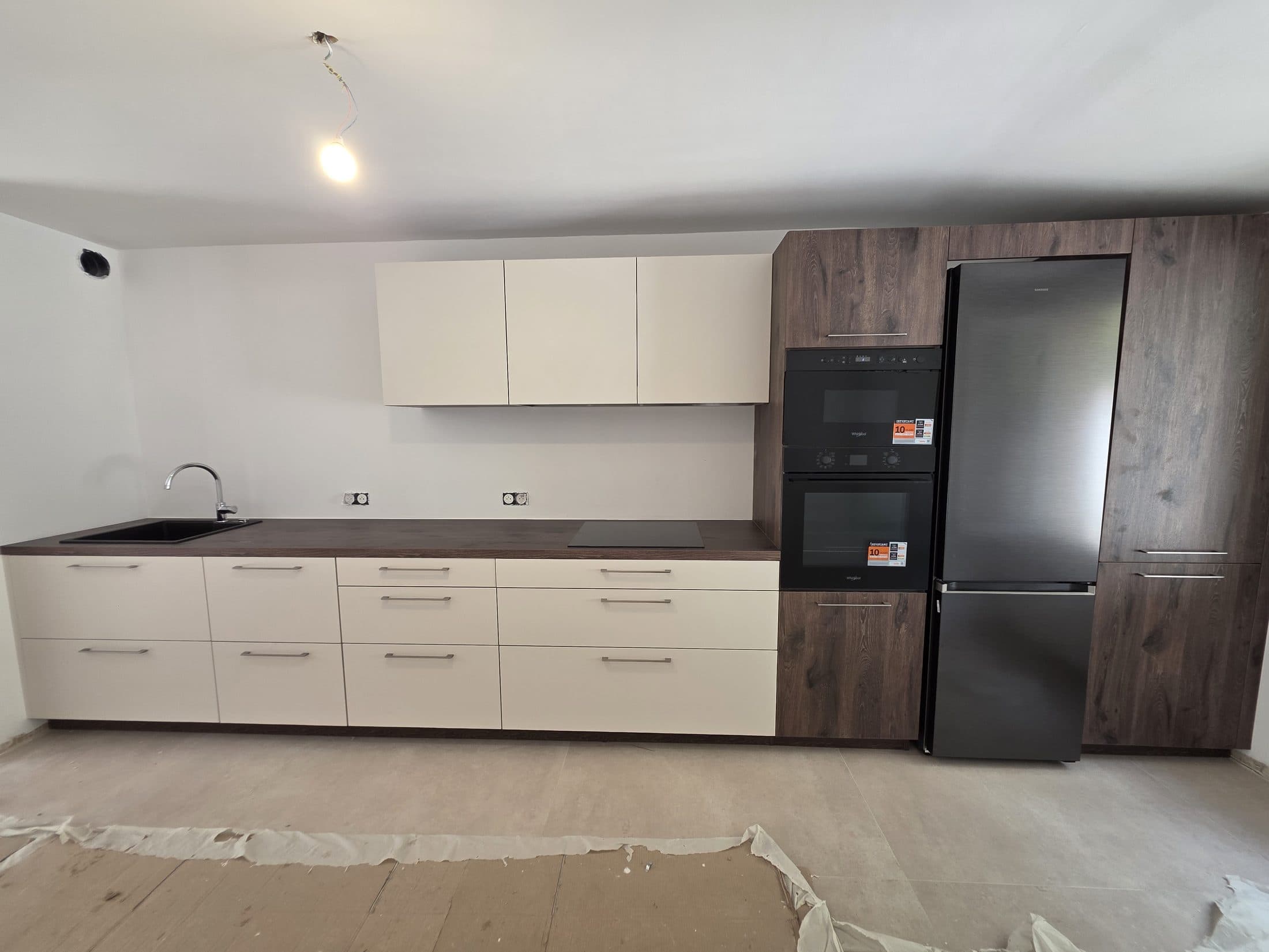 Cuisine blanche avec colonne bois et réfrigérateur noir