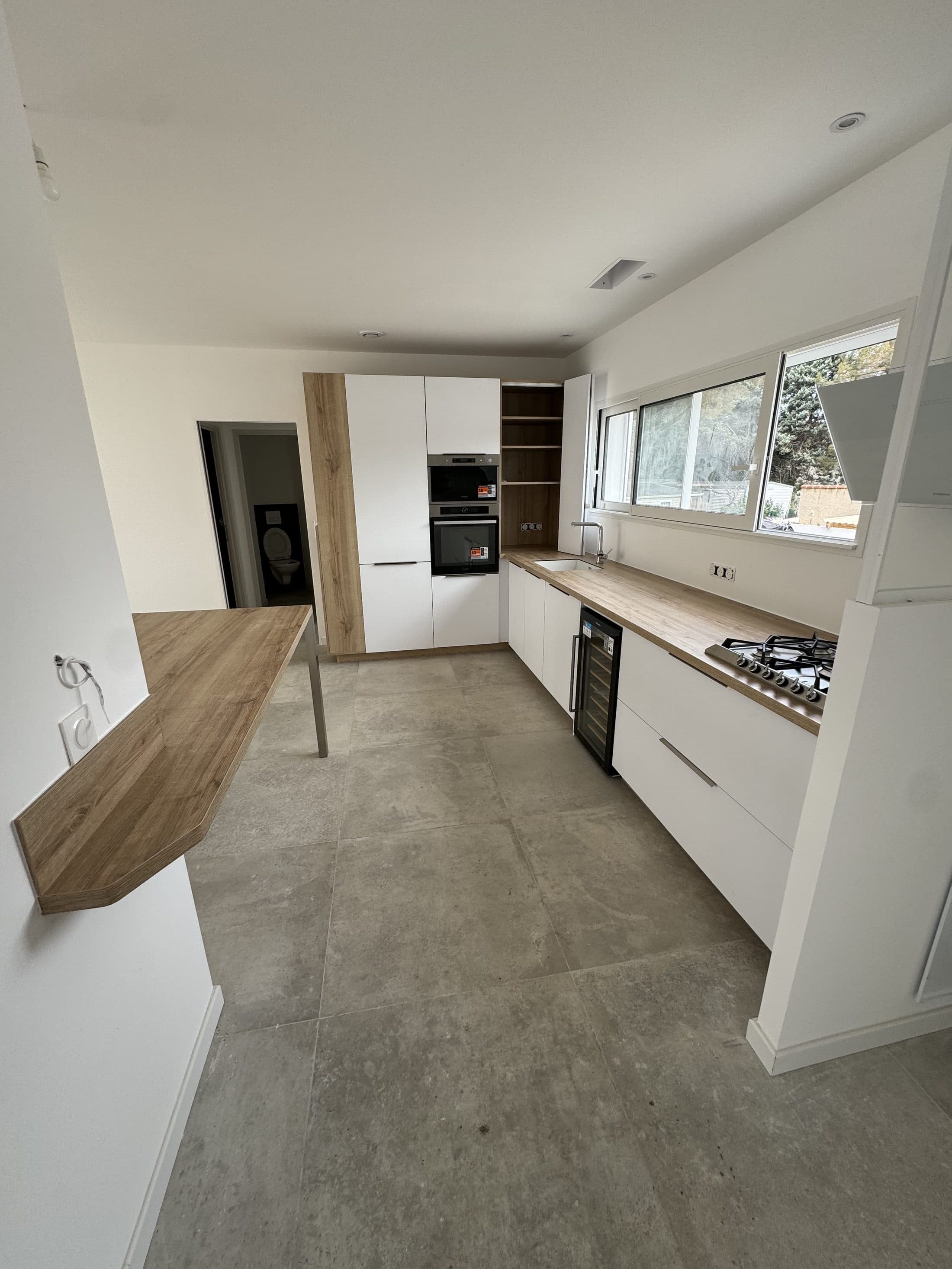 Cuisine blanche avec hotte et bar en bois