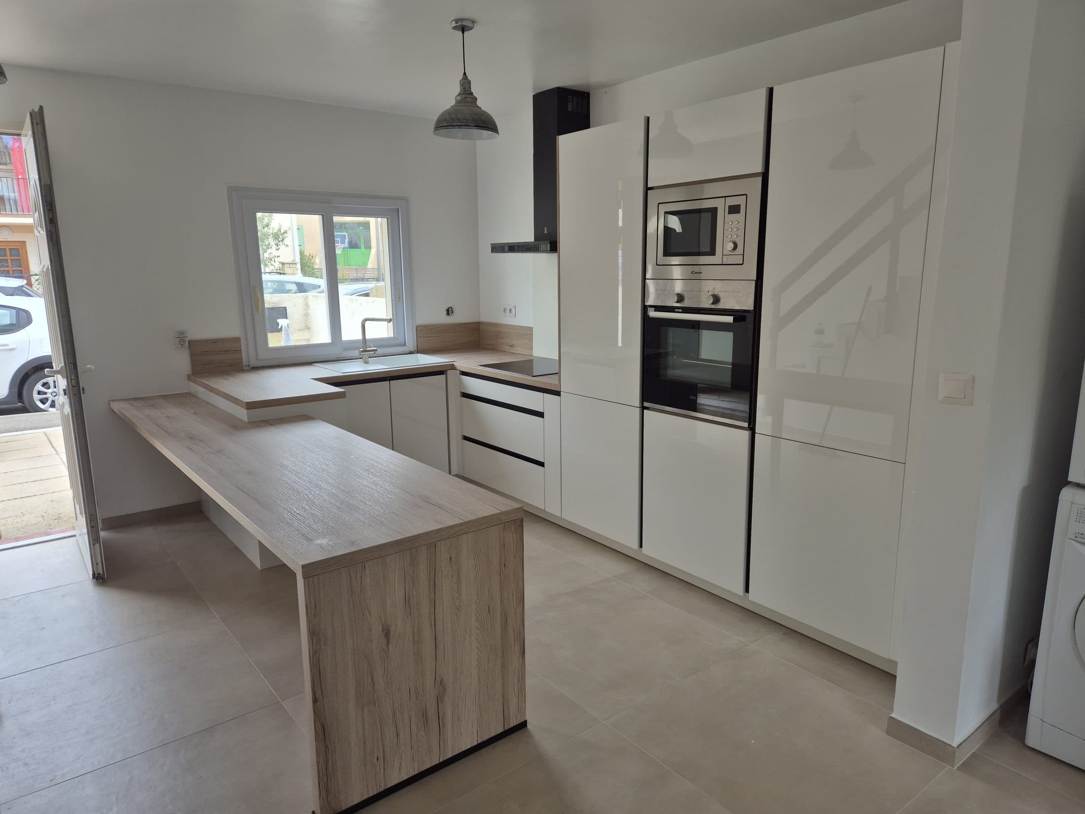Cuisine blanche laquée avec bar en bois et électroménager encastré