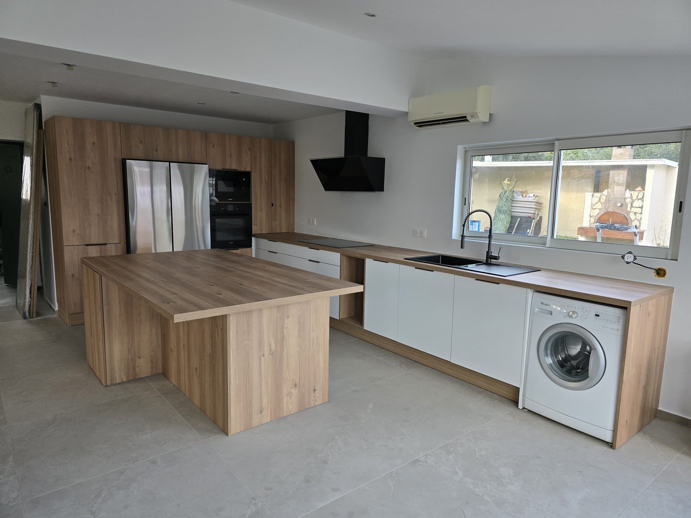 Cuisine bois et blanc avec îlot central et lave-linge intégré