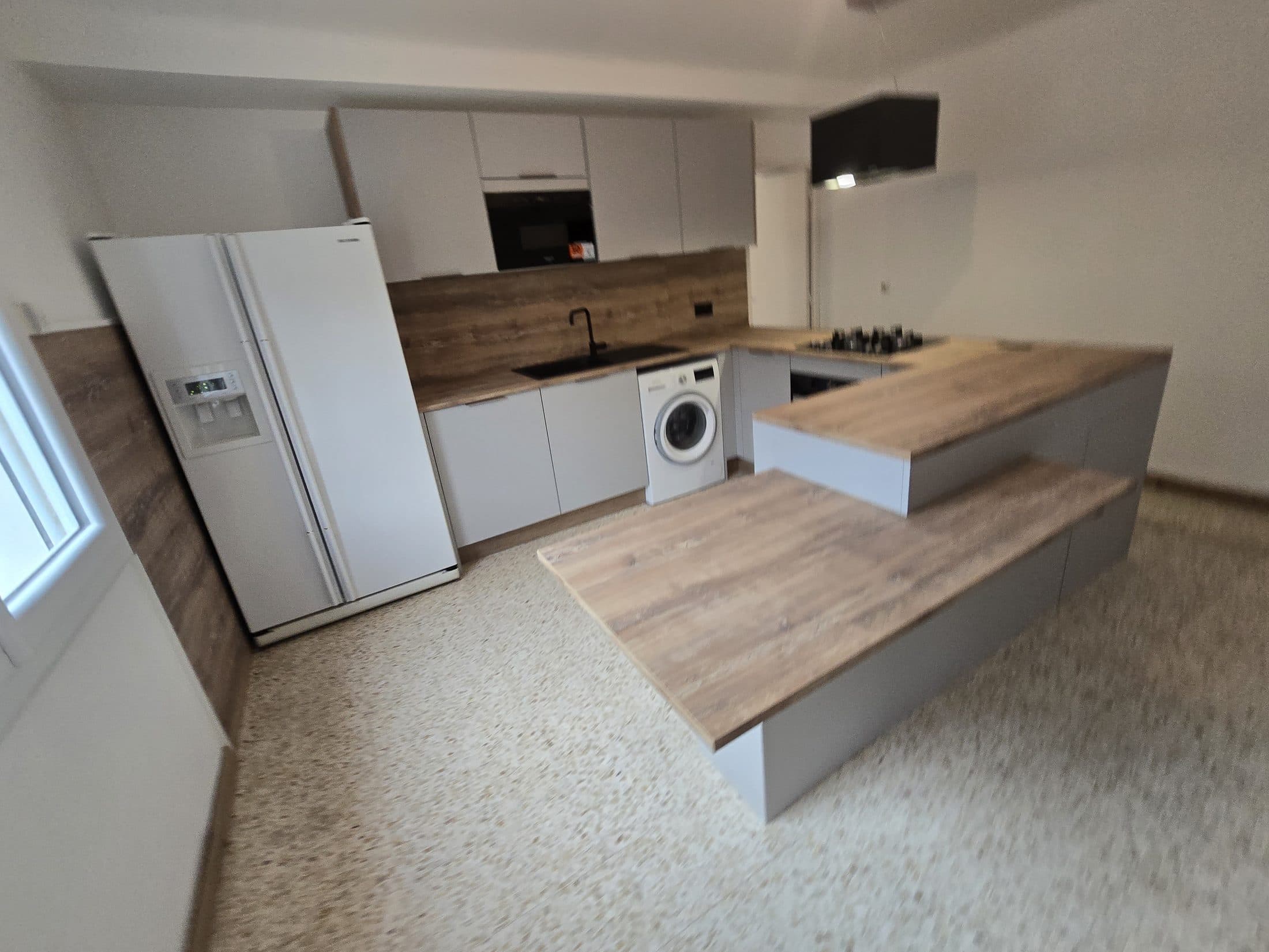 Cuisine compacte blanche avec plan de travail bois et bar