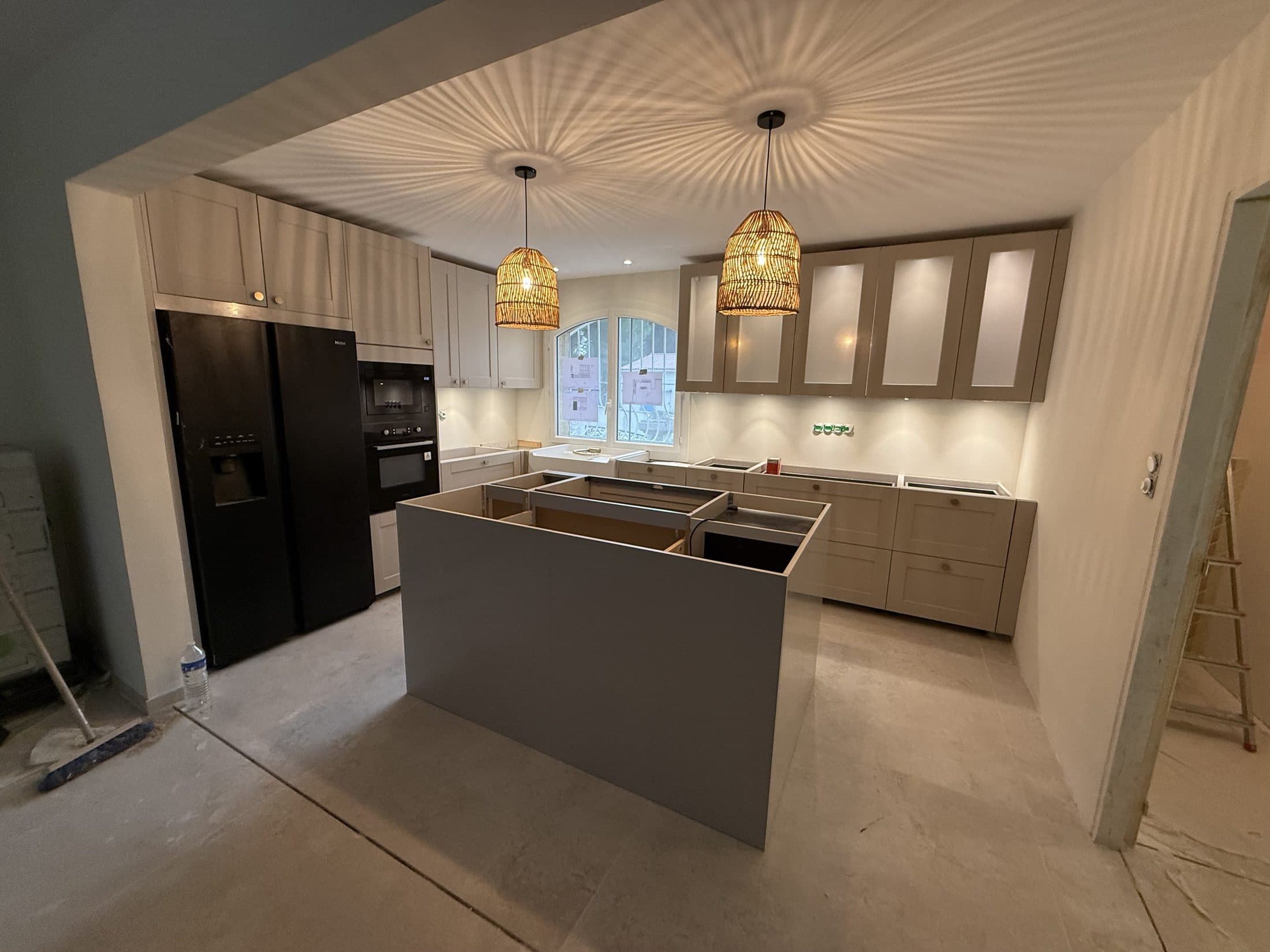 Cuisine avec îlot central et électroménager noir encastré