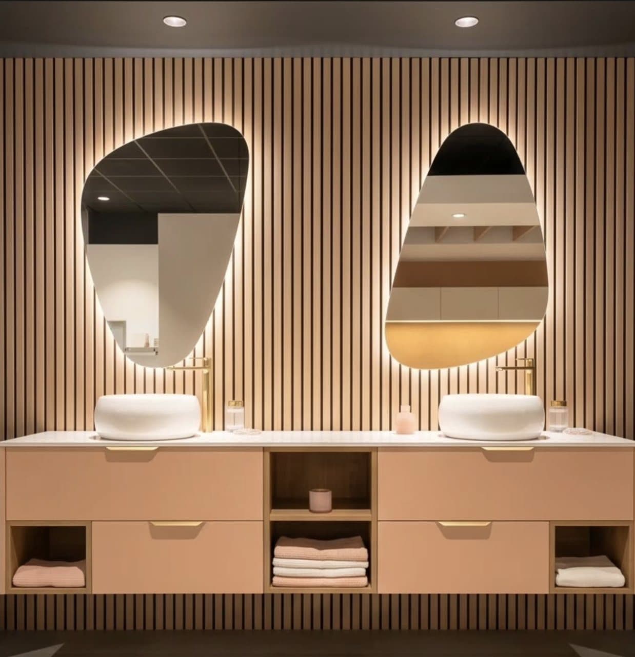 Salle de bain avec miroirs organiques et finitions dorées