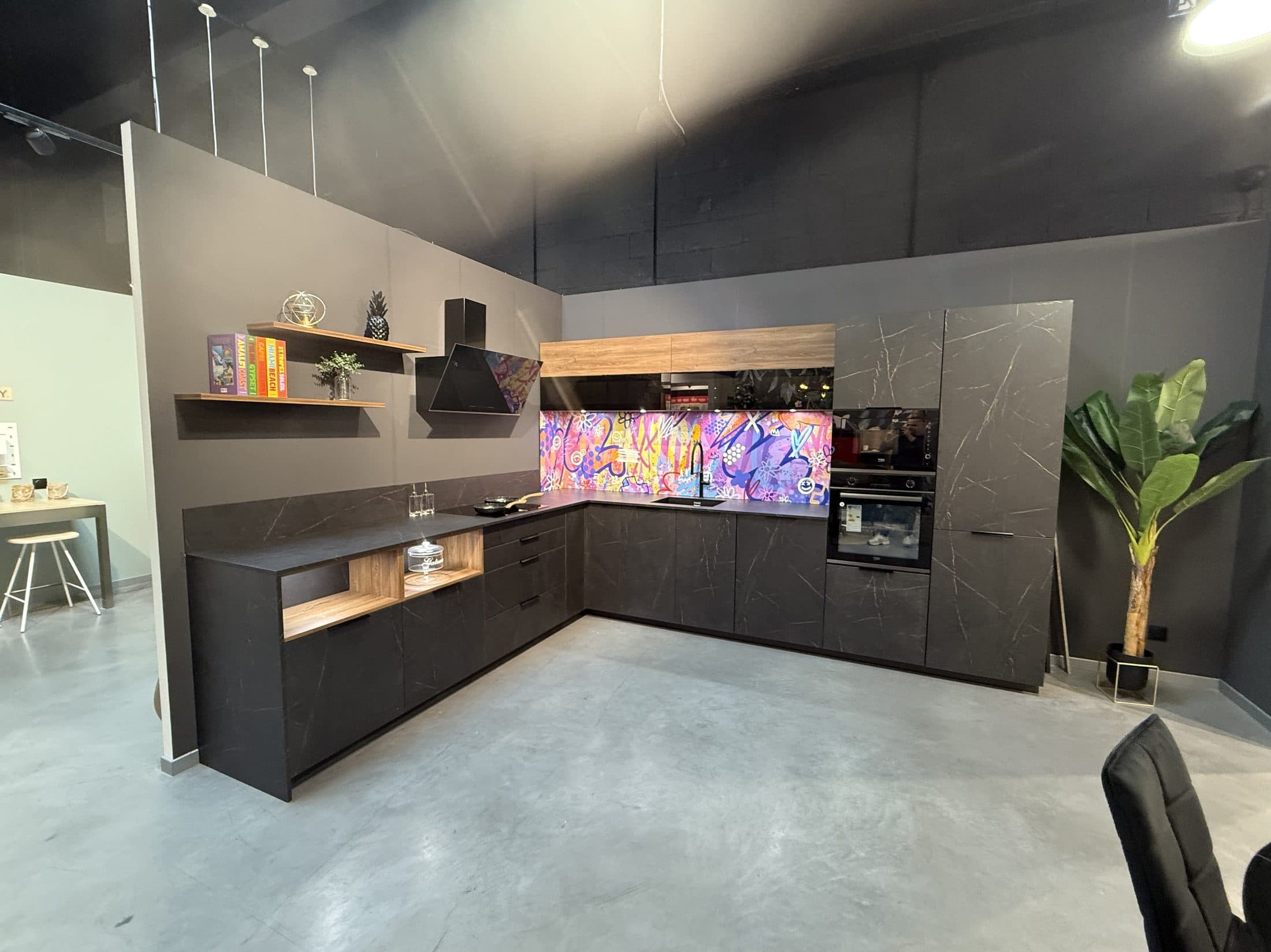Cuisine noire d'exposition avec crédence colorée dans le showroom MPAI